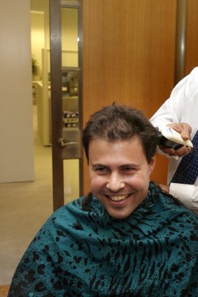 Then prime minister John Howard shaves the head of staffer Josh Frydenberg as part of the annual leukemia fund raising event.