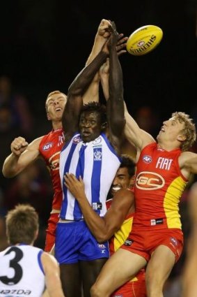 Rory Thompson (loeft) and Trent McKenzie of the Suns contest a mark with Majak Daw of North Melbourne in round seven. 
