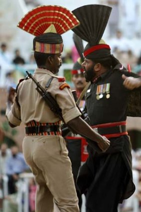 An Indian Border Security Force soldier, left, and a Pakistani Rangers soldier march during Beating the Retreat ceremony.