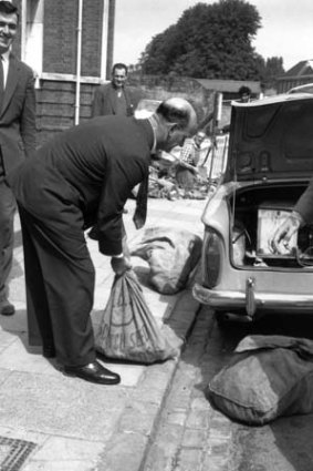 Police officers put bags of evidence into a car boot after the Great Train Robbery.