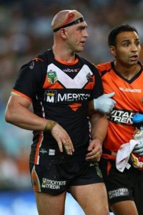Future in doubt: Liam Fulton is escorted from the field in the Tigers clash with Souths in round three.