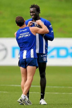 Brent Harvey (L) has a playful shove with Majak Daw at a Kangaroos training session.