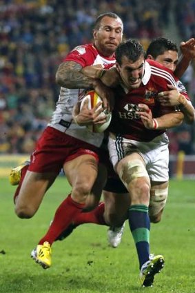 Double-teamed: Quade Cooper and Anthony Fainga'a tackle British and Irish Lions captain Sam Warburton.