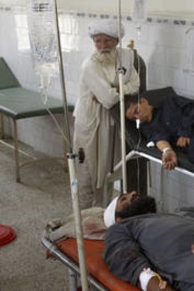 Afghan men comfort relatives who were injured by bomb blasts, at a hospital in Chaman, a Pakistani border town, July 8.