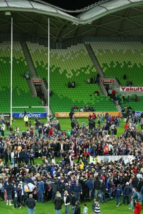 Fans throw their purchased teddy bears into the middle of the ground to raise money for the Good Friday appeal, after the match between the Rebels and the Force.