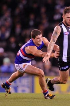 Dane Swan is chased by Tom Liberatore.