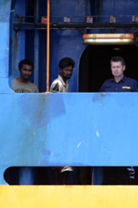 Going nowhere ... an Australian customs official and two of the 78 Sri Lankans aboard the Oceanic Viking yesterday.