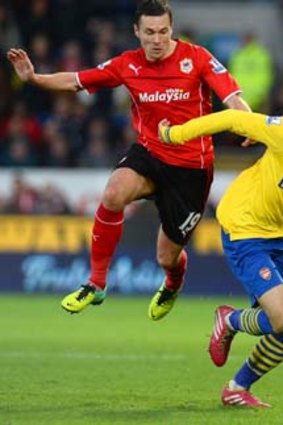 Cardiff City midfielder Don Cowie pursues Arsenal's Aaron Ramsey.