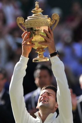 An emotional Novak Djokovic lifts the Wimbledon men's trophy on Sunday.