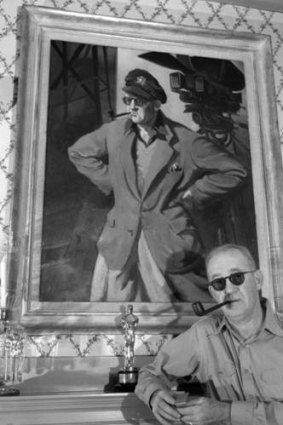 Man and myth: Ford poses in front of a portrait of himself.