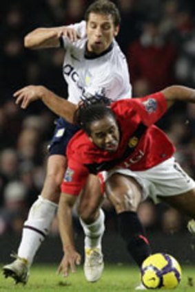 Stumble...Manchester United midfielder Anderson is bowled over by Villa's Stiliyan Petrov.