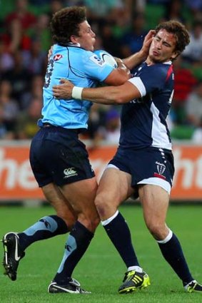 Indefensible: Rebel Danny Cipriani gets to grips with Waratah's Luke Burgess bakc in round one.