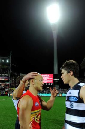 Geelong's Andrew Mackie talks to Suns' captain Gary Ablett after the game.