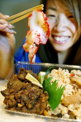 A Japanese woman uses chopsticks to pick up a slice of whale bacon  at a whale meat tasting in Tokyo.