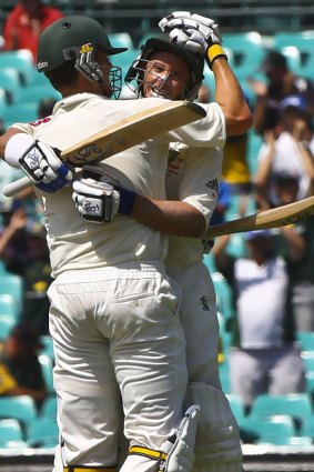 Partners in crime . . . Mike Hussey gets a hug from Peter Siddle after making his century.
