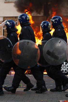 Riot police framed by flame in Hackney.
