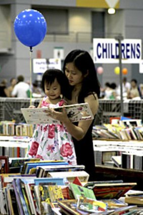 Child's play ... Amy Quek and daughter Samantha Yeo check out the bargains at the Lifeline Bookfest.