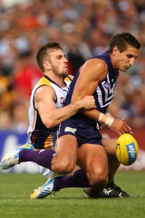 Eric Mackenzie of the Eagles tackles Matthew Pavlich of the Dockers during the round one match at Patersons Stadium.
