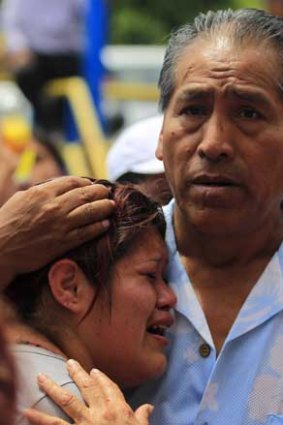 A man and woman despair as they wait outside a rehabilitation centre that caught alight in Lima.