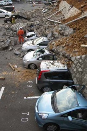 Collapse ... vehicles crushed by a car park wall in Mito City, Ibaraki prefecture.