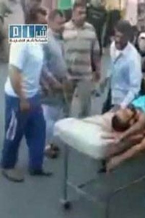 Hama residents rush an injured man to hospital.