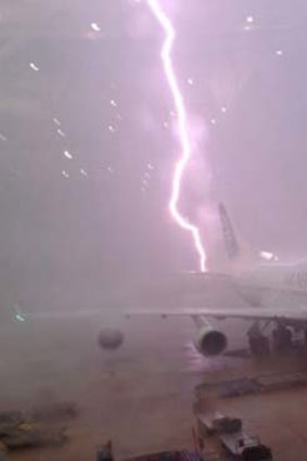 Near miss ... a lightning strike just misses a plane at Brisbane airport.