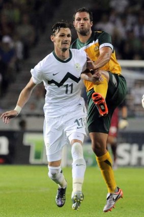 Slovenia's Milivoje Novakovic (11) fights for the ball with Australia's Nikita Rukavytsya.