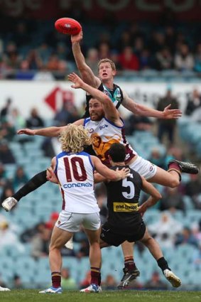Power punch: Port Adelaide’s Matthew Lobbe, who was later injured, wins the tap over Brisbane’s Ben Hudson.