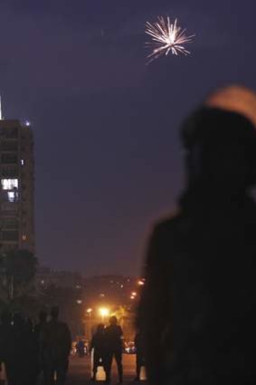 Fireworks are seen as army soldiers take their positions in front of protesters.