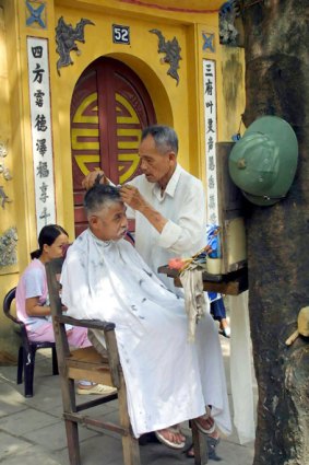 In touch with the locals ... an open-air barber shop does a brisk trade.