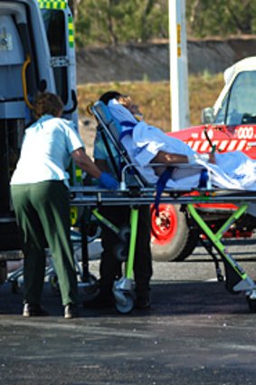 Paramedics help Pat Rudland into an ambulance following the crash.