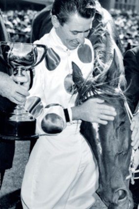Jockey Roy Higgins celebrates winning the 1965 Melbourne Cup on Light Fingers - the first of twelve such triumphs for Bart Cummings at Flemington.