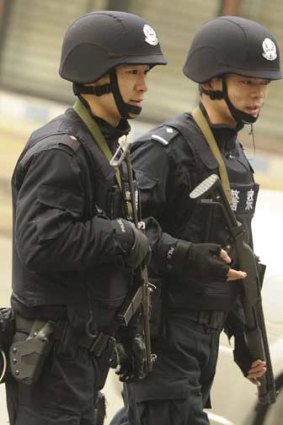 Armed Chinese police patrol on a street in Chengdu.