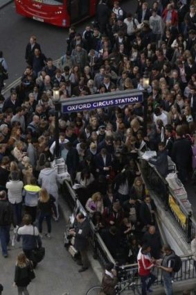 Commuters and shoppers queue for access to Oxford Circus underground station.