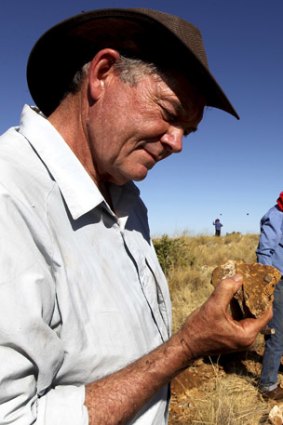 Michael Archer studies a rock as his team sift through the dirt and dust of Riversleigh.