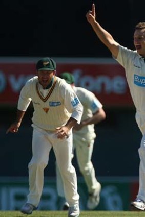 Evan Gulbis of the Tigers celebrates with Ricky Ponting after taking the wicket of Peter Forrest.