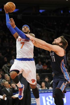 Carmelo Anthony sets up a shot as he gets by Josh McRoberts of the Charlotte Bobcats during the first quarter of the game on Friday.