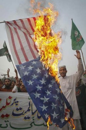 Supporters from religious political party Sunni Tehreek demonstrate against a NATO cross-border attack by burning an American flag.