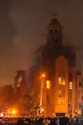 Egyptians gather as firefighters extinguish a fire on a church after clashes between Muslims and Christians in Cairo.