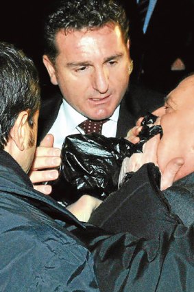 Silvio Berlusconi is helped by police after he was attacked in Milan after the attack.