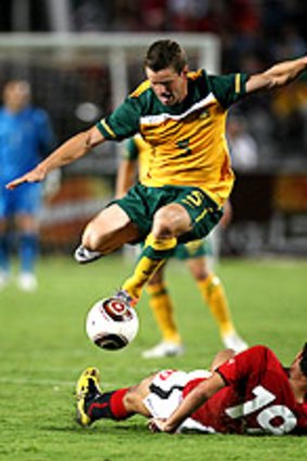 Australia's Jason Culina leaps over a challenge from Ahmed Samir Farag in Cairo.
