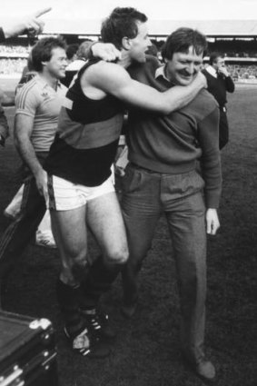 First flag as coach: Tim Watson hugs Sheedy after the Bombers turned the tables on the Hawks in the 1984 grand final.