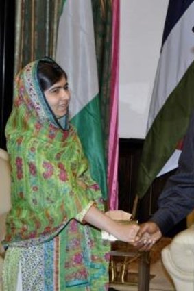 Malala Yousafzai shakes hands with Nigerian President Goodluck Jonathan.
