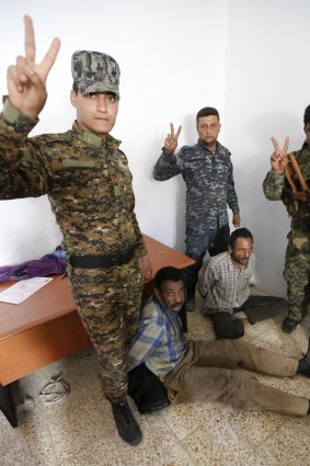 Shiite paramilitary fighters and Iraqi security forces arrest Islamic State militants in Tikrit this week.