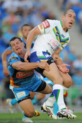 Greg Bird of the Titans tackles Terry Campese of the Raiders after kicking the ball during the round two NRL match between the Gold Coast Titans and the Canberra Raiders at Skilled Park on March 10, 2012 in Gold Coast, Australia.  (Photo by Matt Roberts/Getty Images)