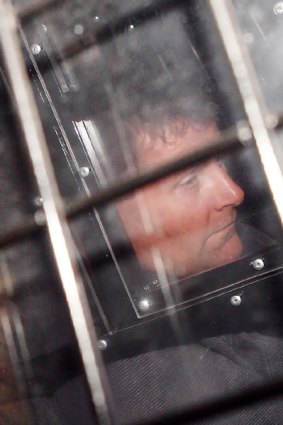 NSW Crime Commission officer Mark Standen arrives handcuffed at court in a secured vehicle. PICTURE: JON REID