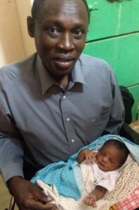 Daniel Wani carrying his newborn daughter Maya at the womens prison.