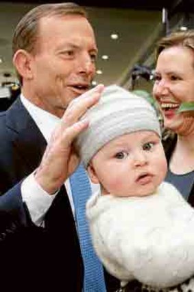 Gentle touch: Abbott meets baby Thomas.