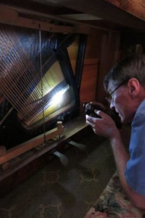 Chris Leslie makes a preliminary assessment of a now-restored piano.