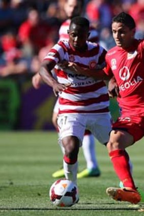 Youssouf Hersi of the Wanderers contests the ball with Marcelo Carrusca of Adelaide United.